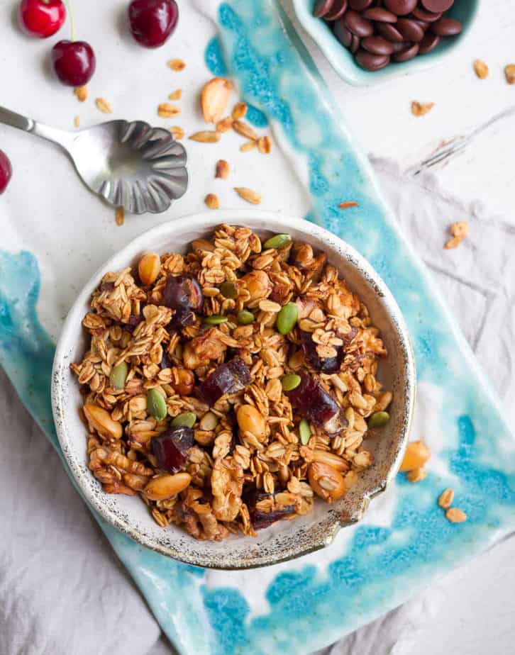 Baked banana granola in a bowl on a blue tray.