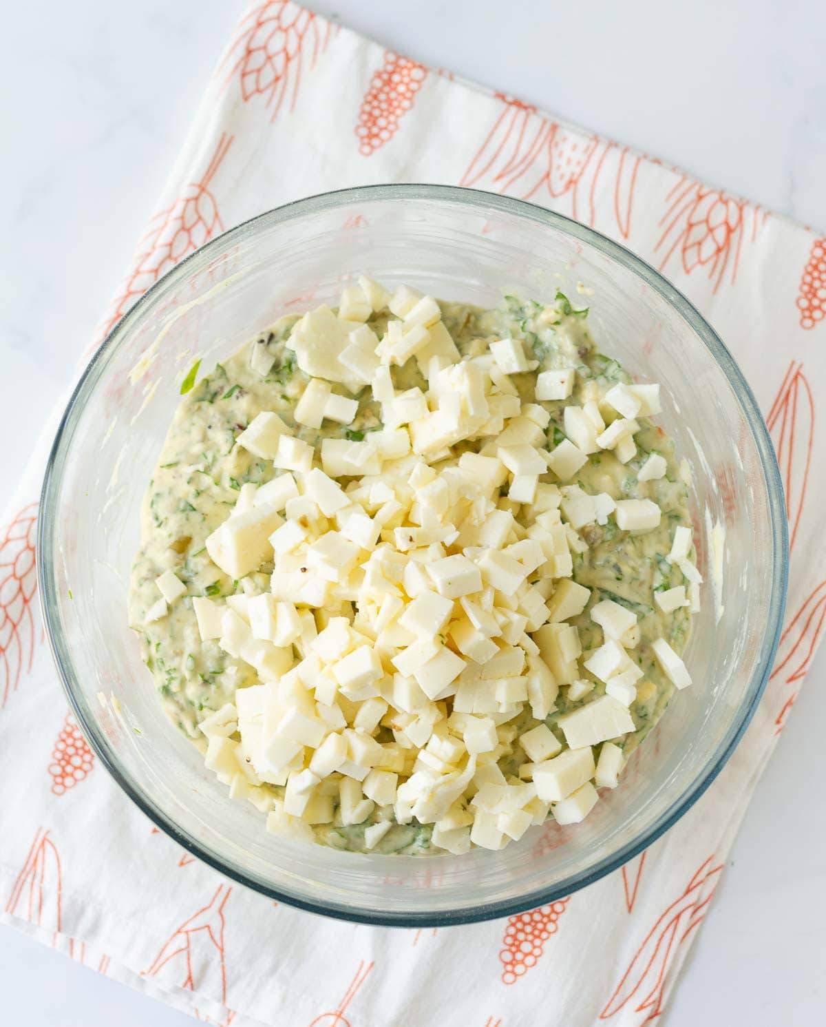 Cubed feta cheese on top of the muffin batter.