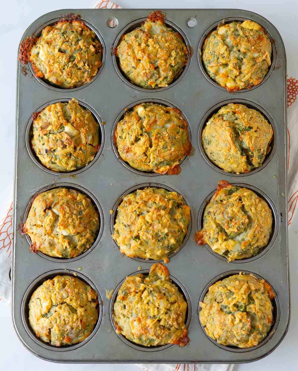 Baked feat spinach muffins in a baking tray.