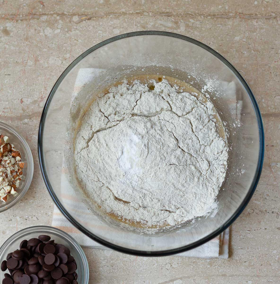 Wet and dry ingredients in a bowl with other ingredients around.