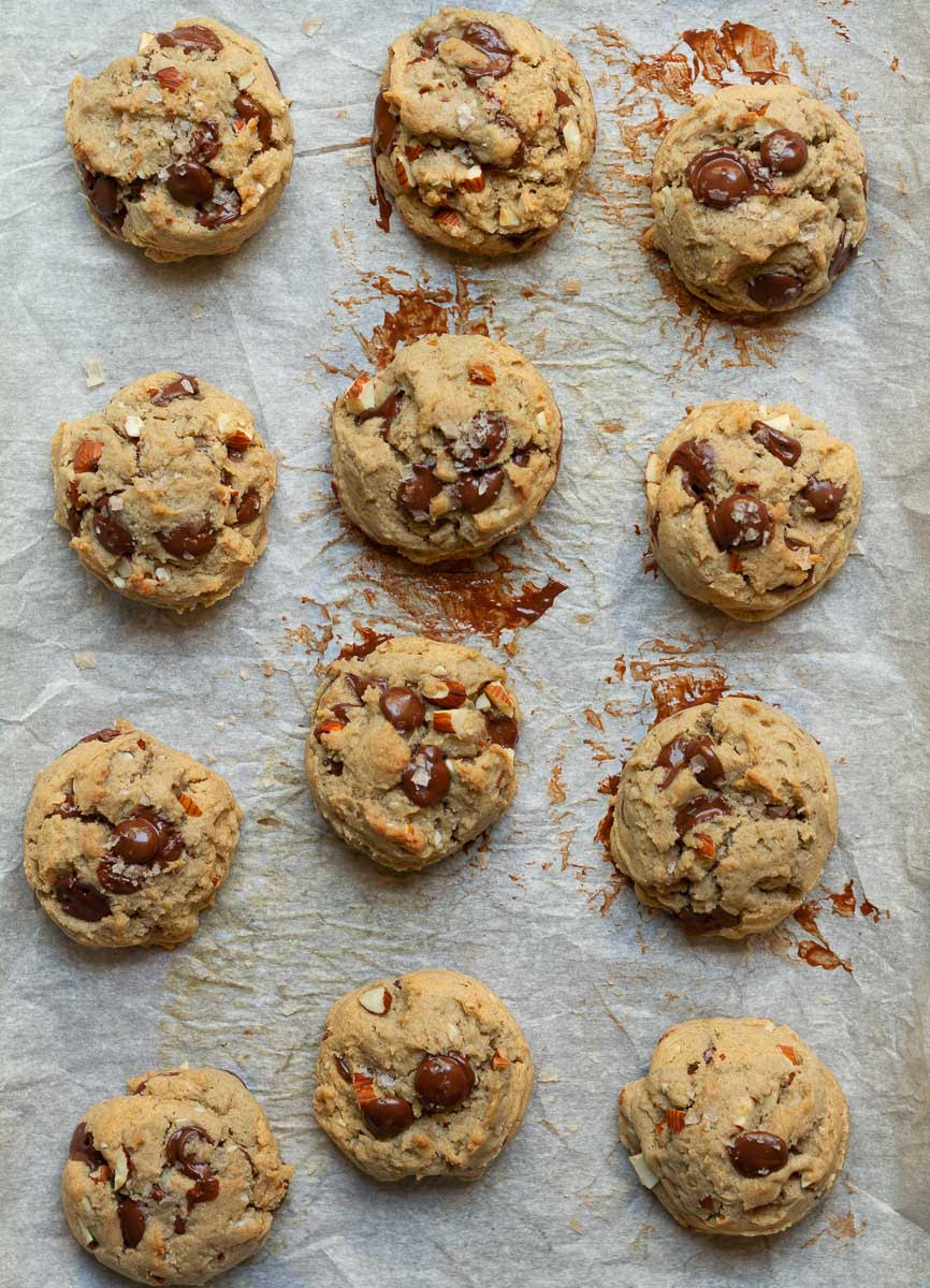 Baked gluten-free chocolate chip cookies on a parchment lined tray.