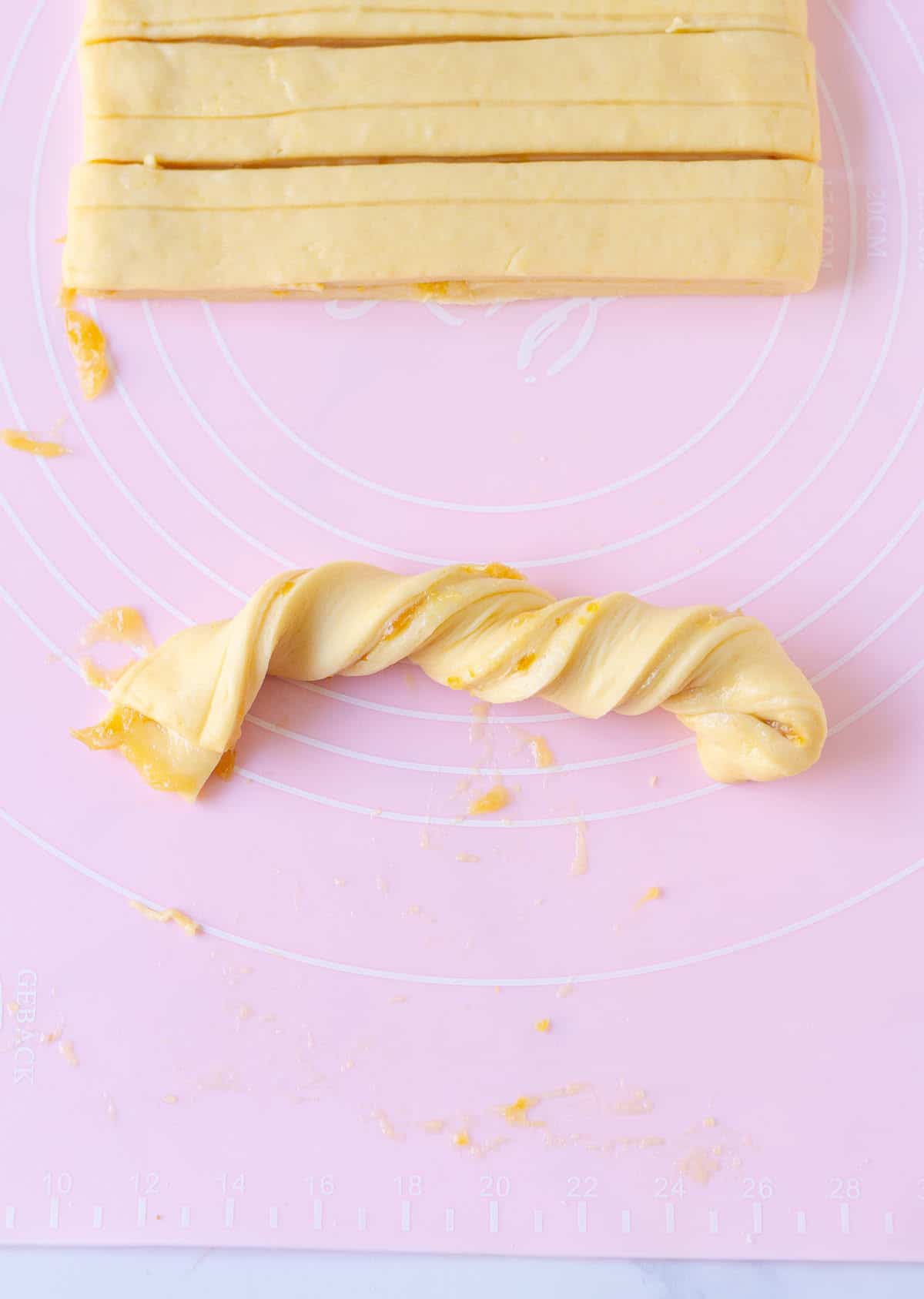 A twisted dough piece on a silicone mat.