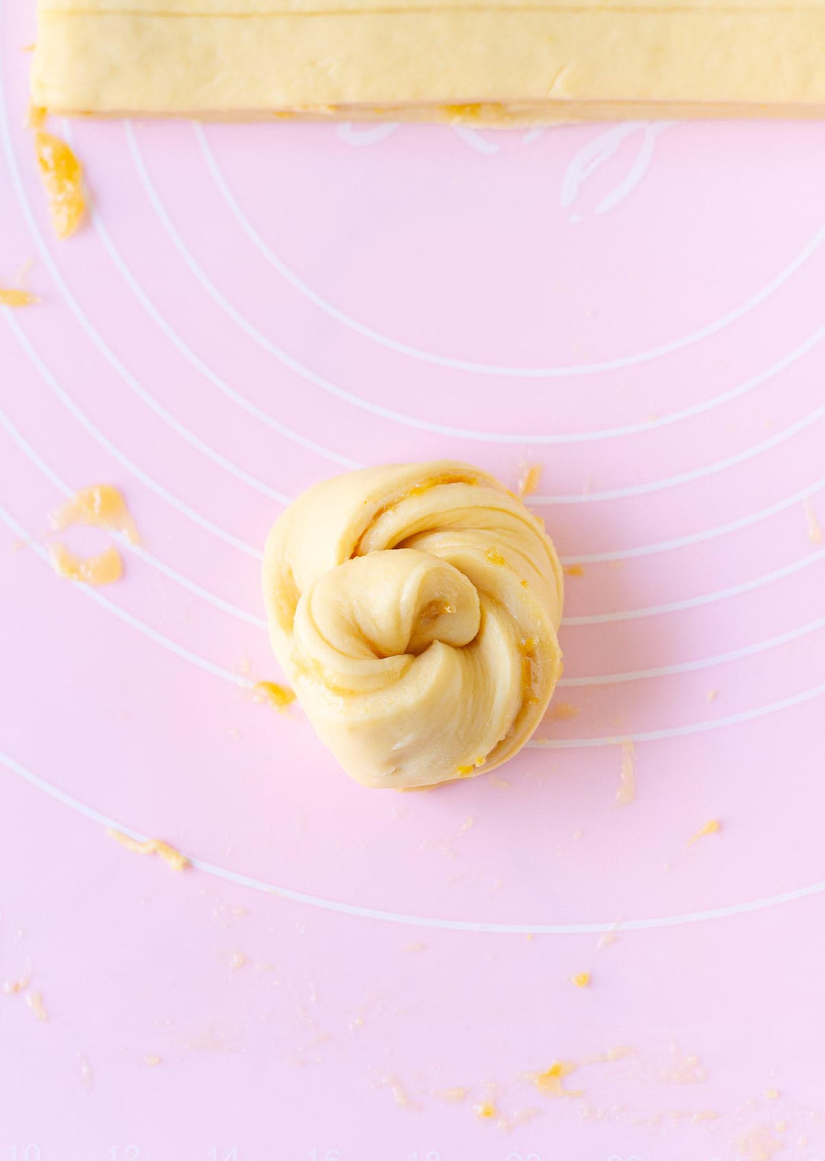 Twisted shaped dough roll on a silicone mat.