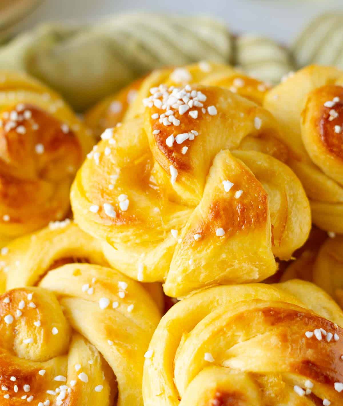 orange brioche rolls topped with pearl sugar.