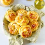 orange brioche sweet rolls piled up on a green napkin.