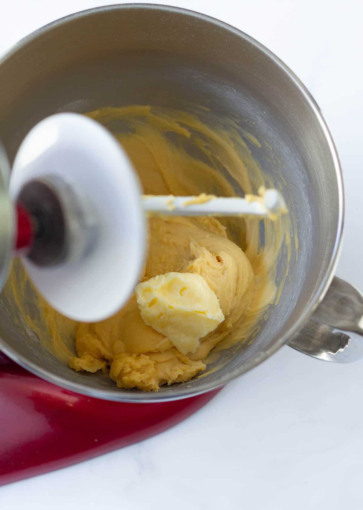 Butter on the bread dough in a stand mixer bowl.