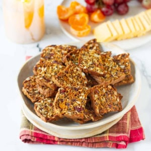 pumpkin cranberry crackers in a bowl on a plaid napkin.