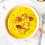 roasted sweet potato soup in a bowl garnished with croutons and thyme.