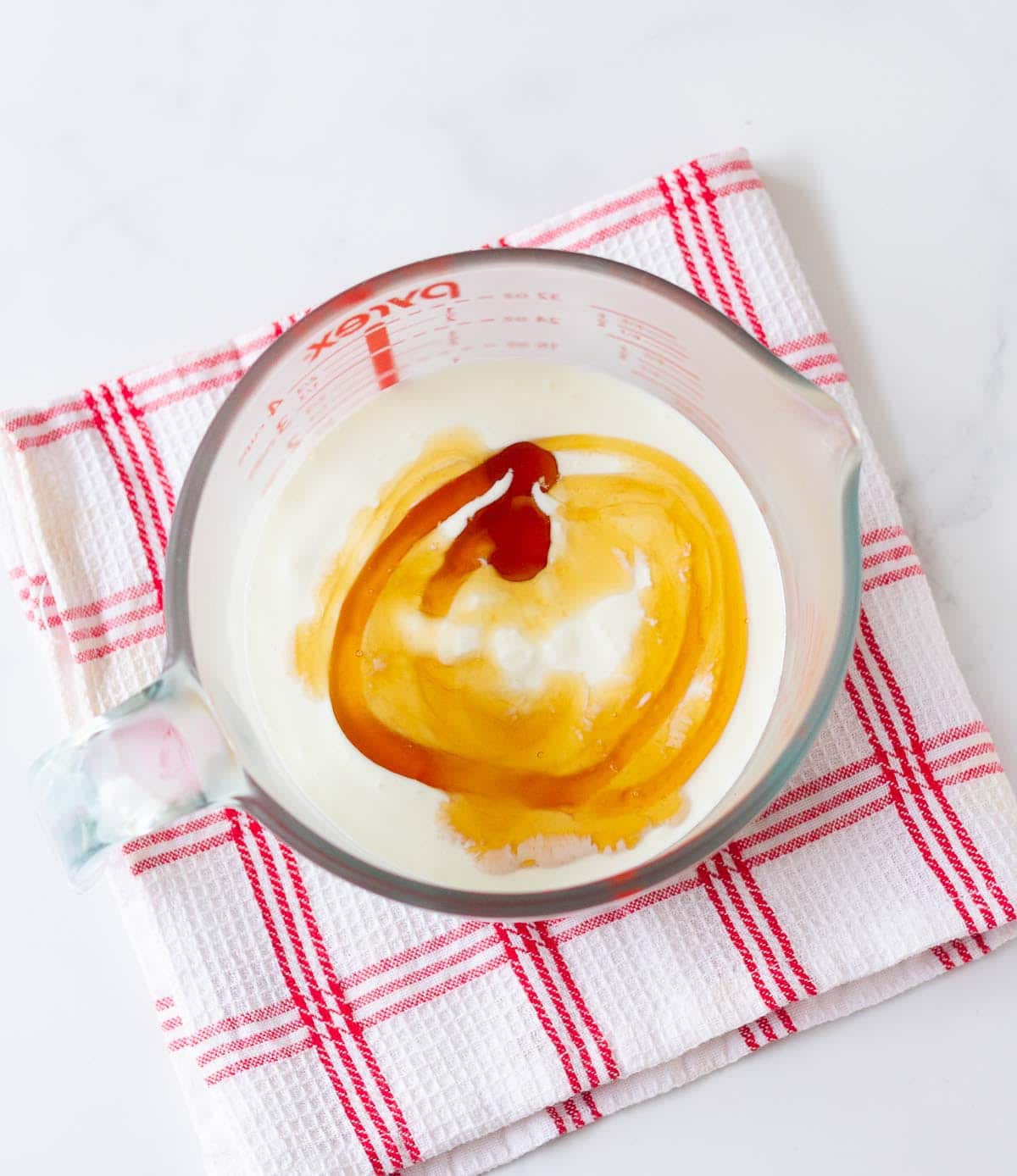 yogurt and honey in a glass measuring jar.