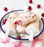 4 cherry popsicles in a bowl with ice and cherries.