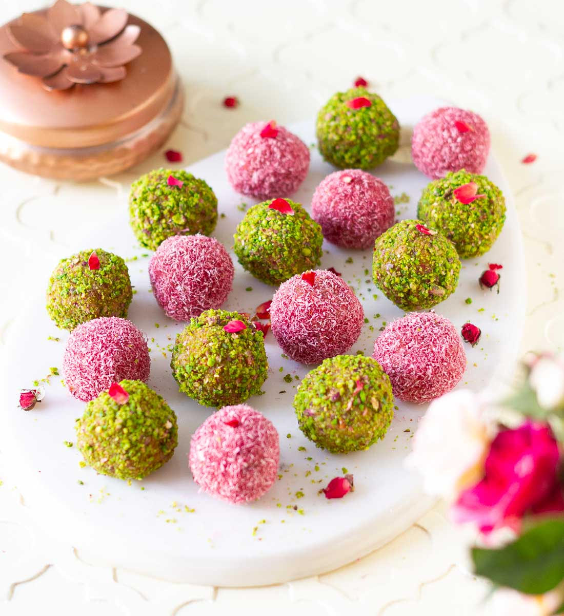 Coconut Almond Bliss Balls coated with pistachios and pink hued coconut.