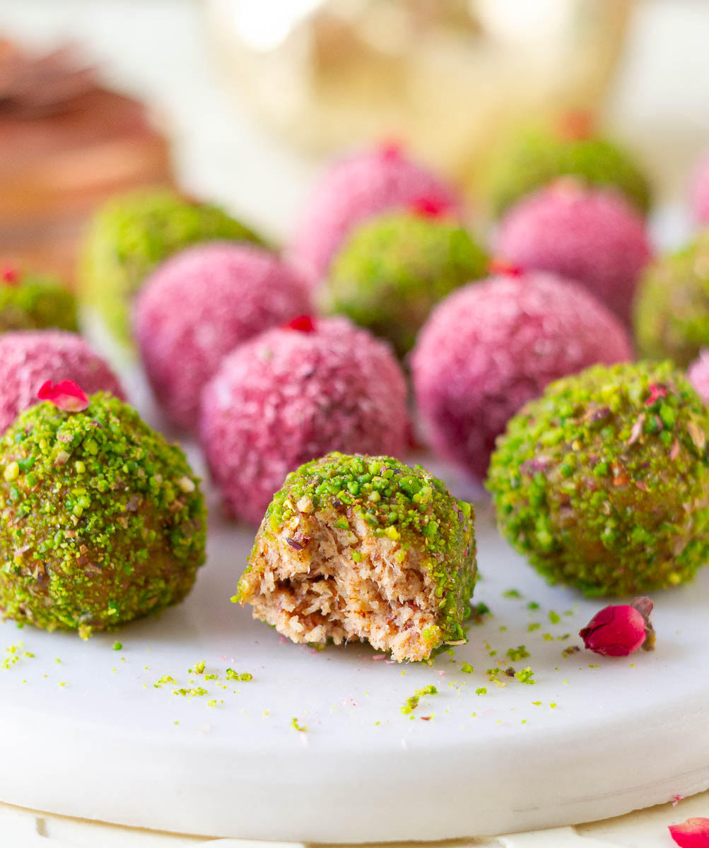 Half eaten bliss ball on a tray with more bliss balls.