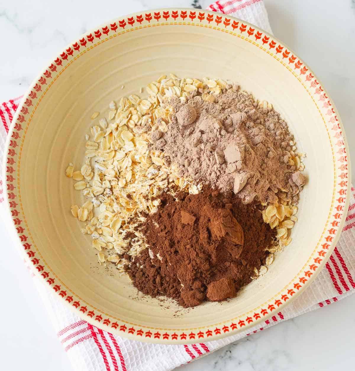 rolled oats, protein powder and cocoa powder in a mixing bowl.