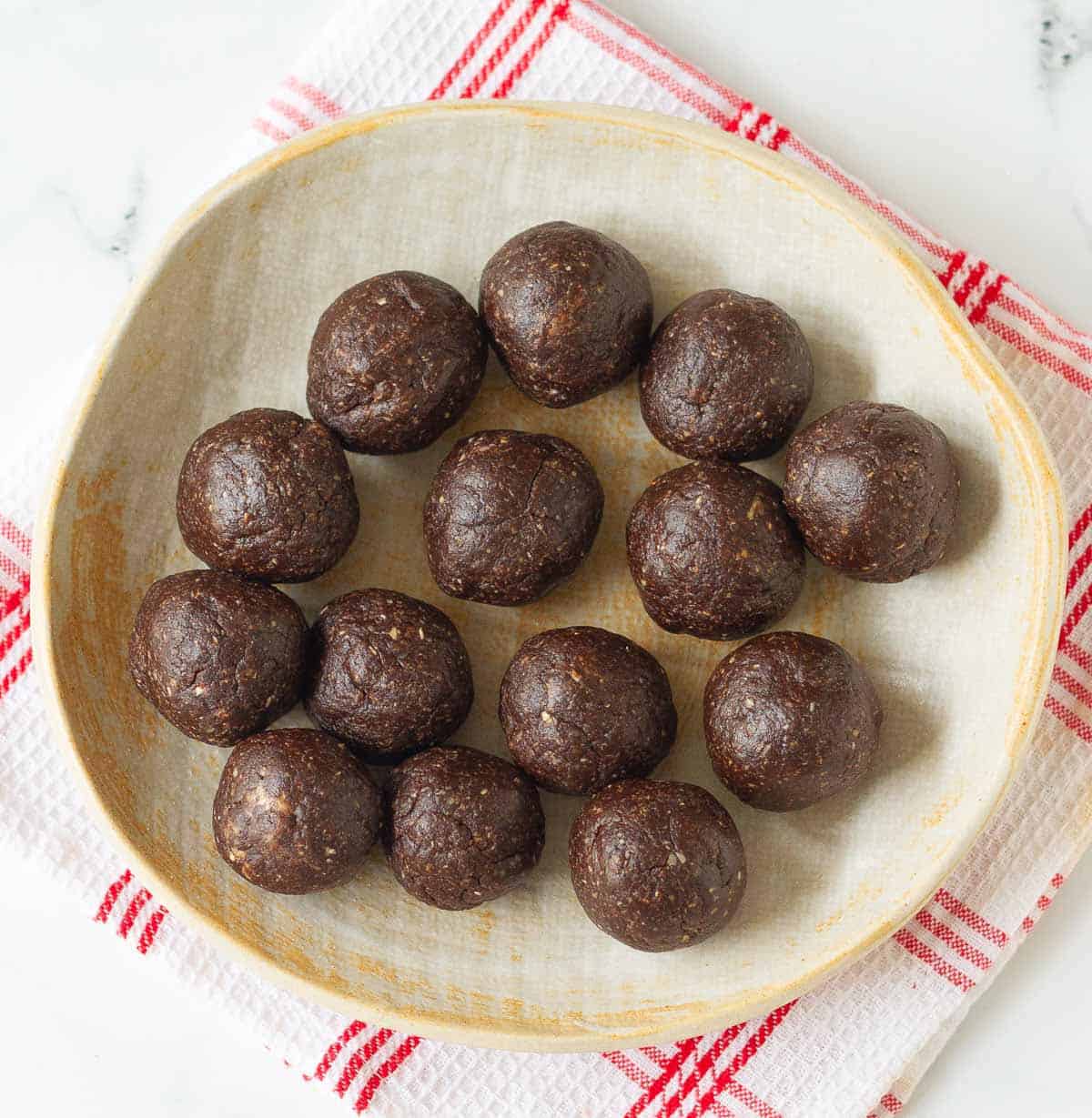 peanut butter chocolate dough rolled into 14 balls on a plate.