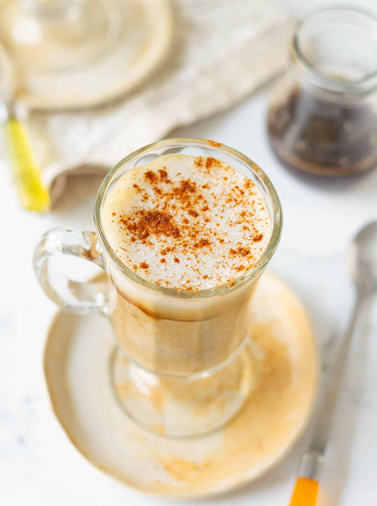 oatmeal latte with a sprinkle of cinnamon powder in a mug.