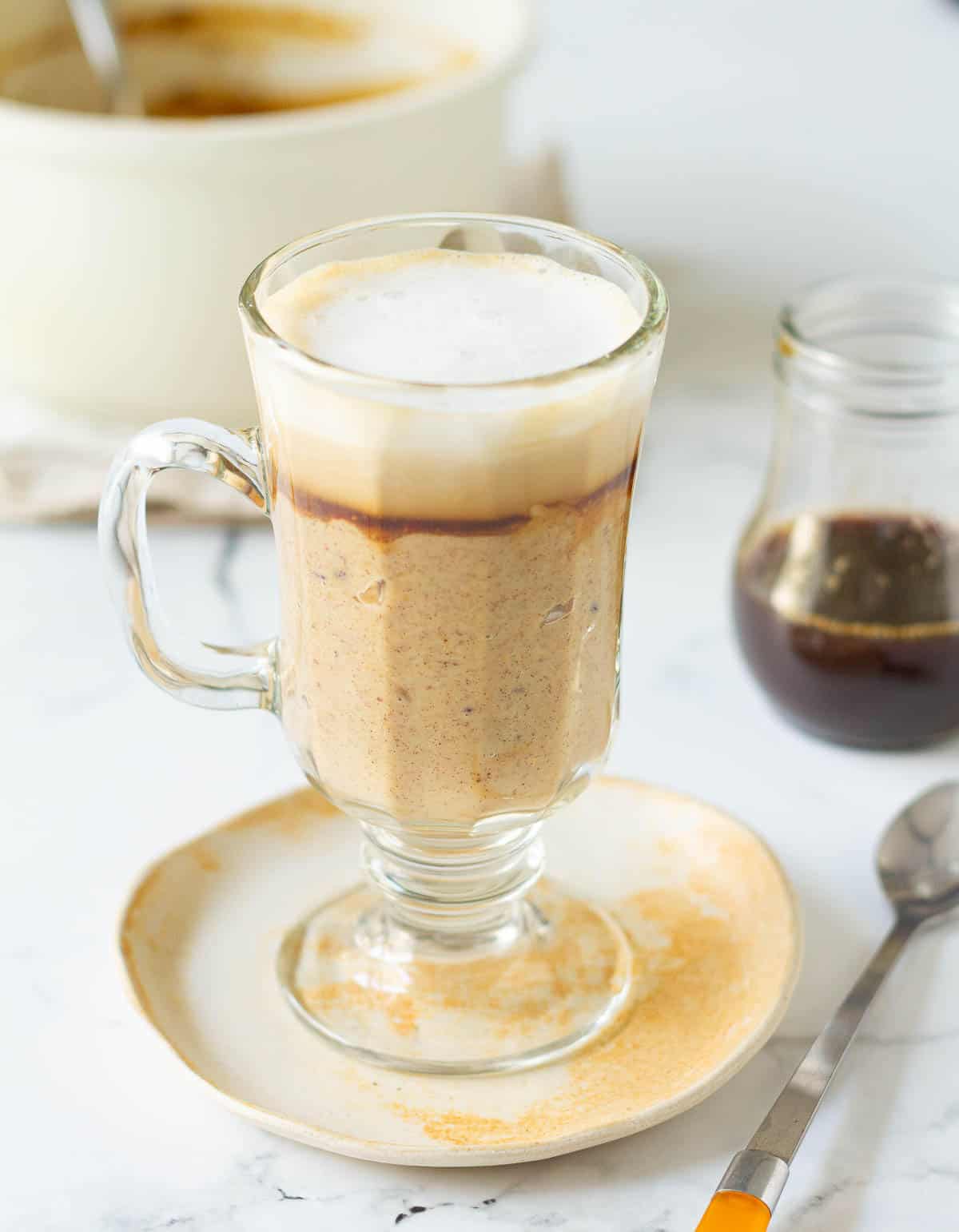 coffee oatmeal topped with steaming hot milk and foam.