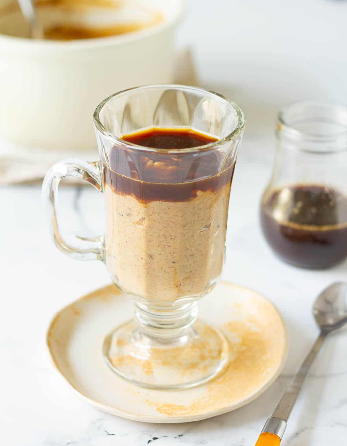 oatmeal topped with brewed coffee in a glass mug.