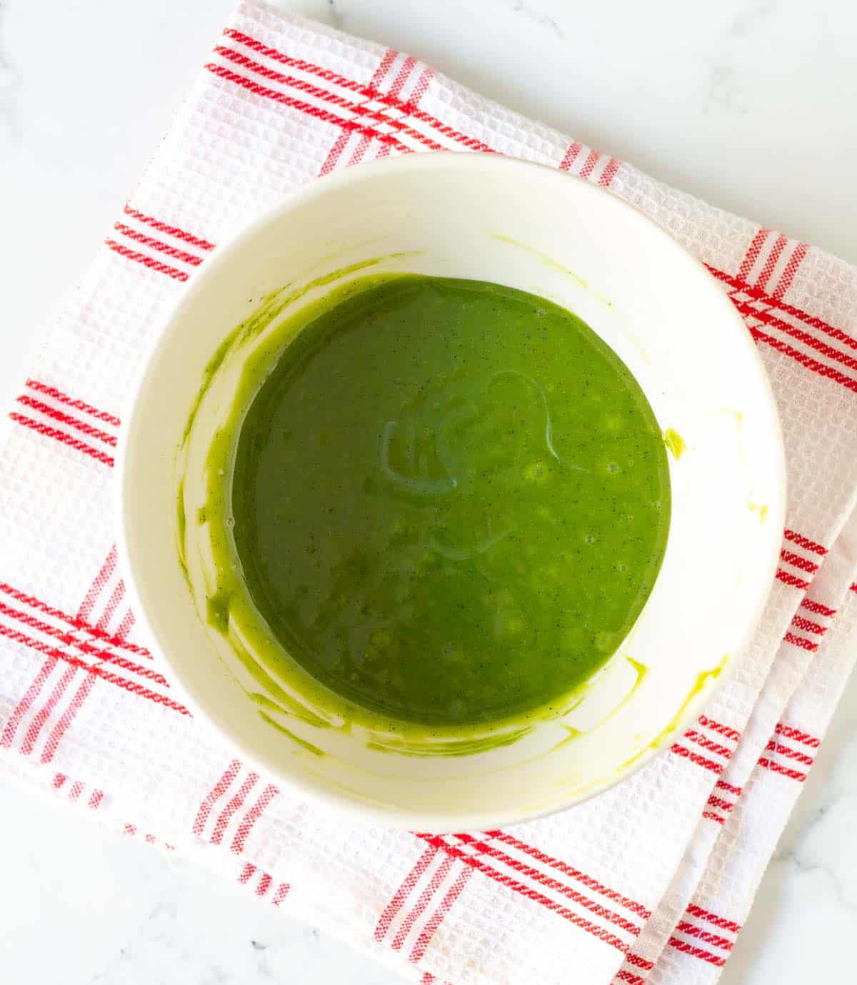 White chocolate mixture with matcha powder in a mixing bowl.