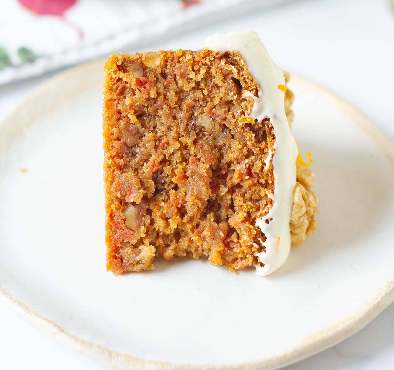 A slice of carrot cake on a plate to show its texture.