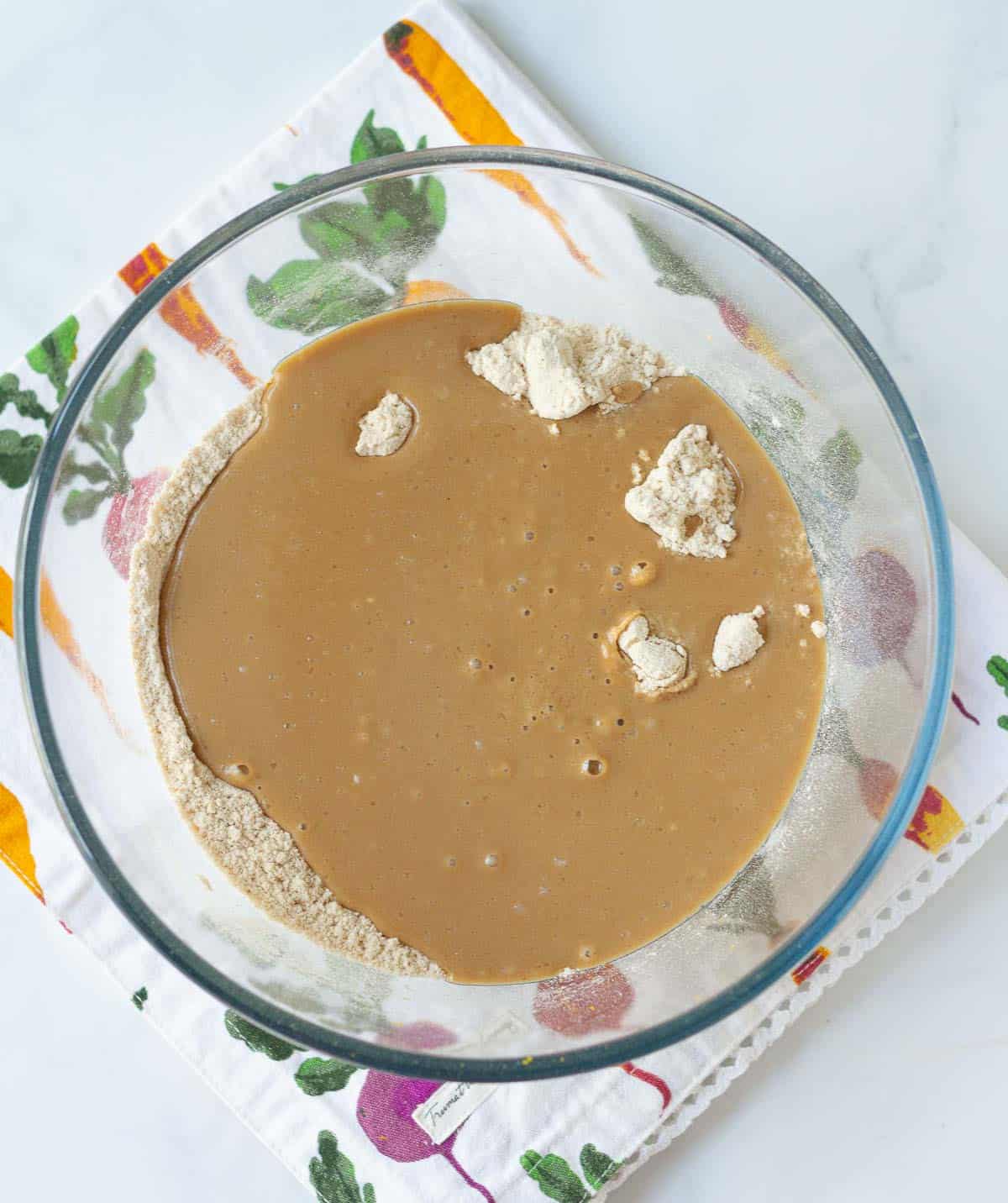 Dry and wet ingredients in a mixing bowl to make cake batter.