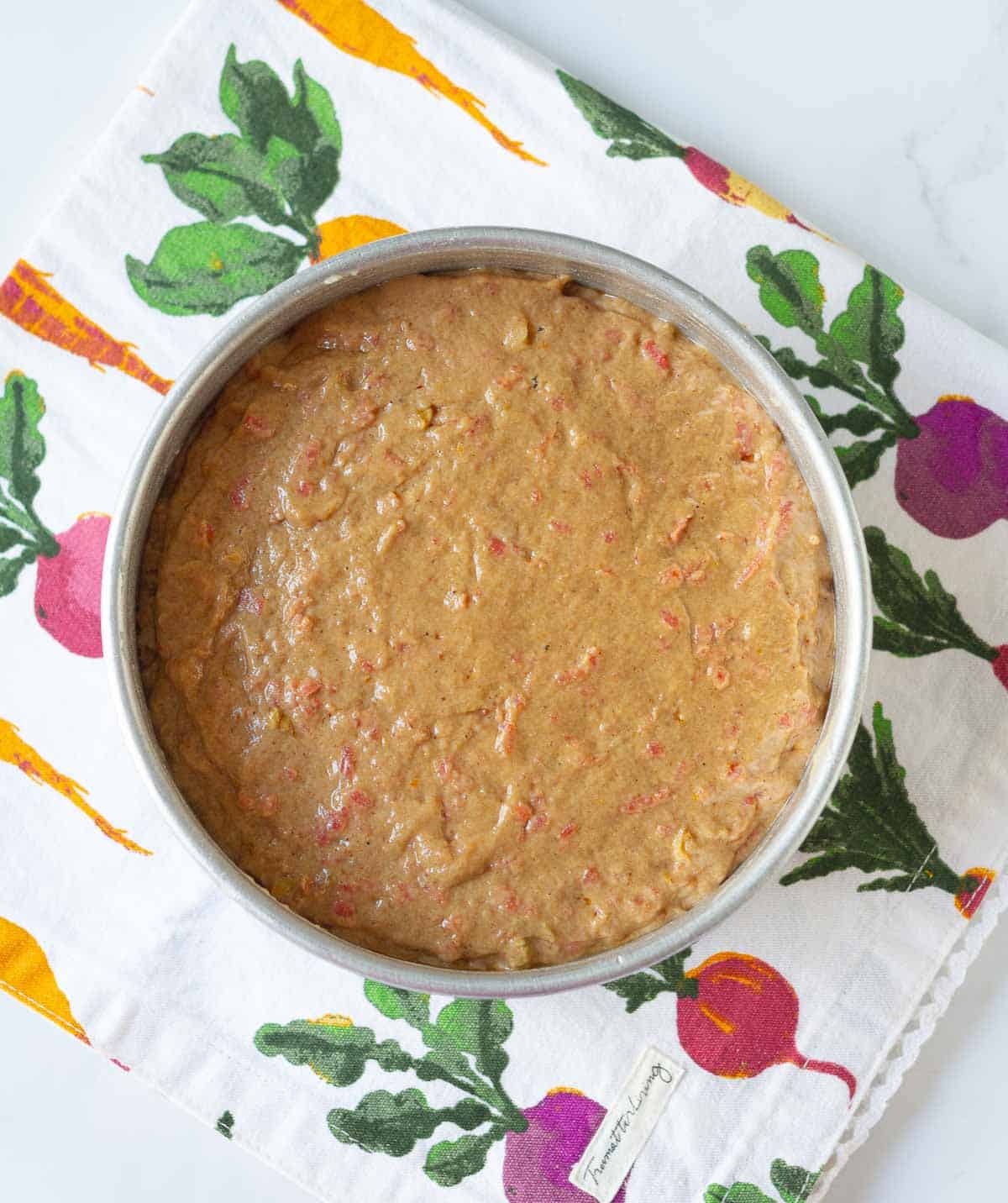 Cake batter in a round cake tin.