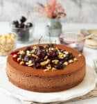 Chocolate cheesecake with cherry sauce on a platter.