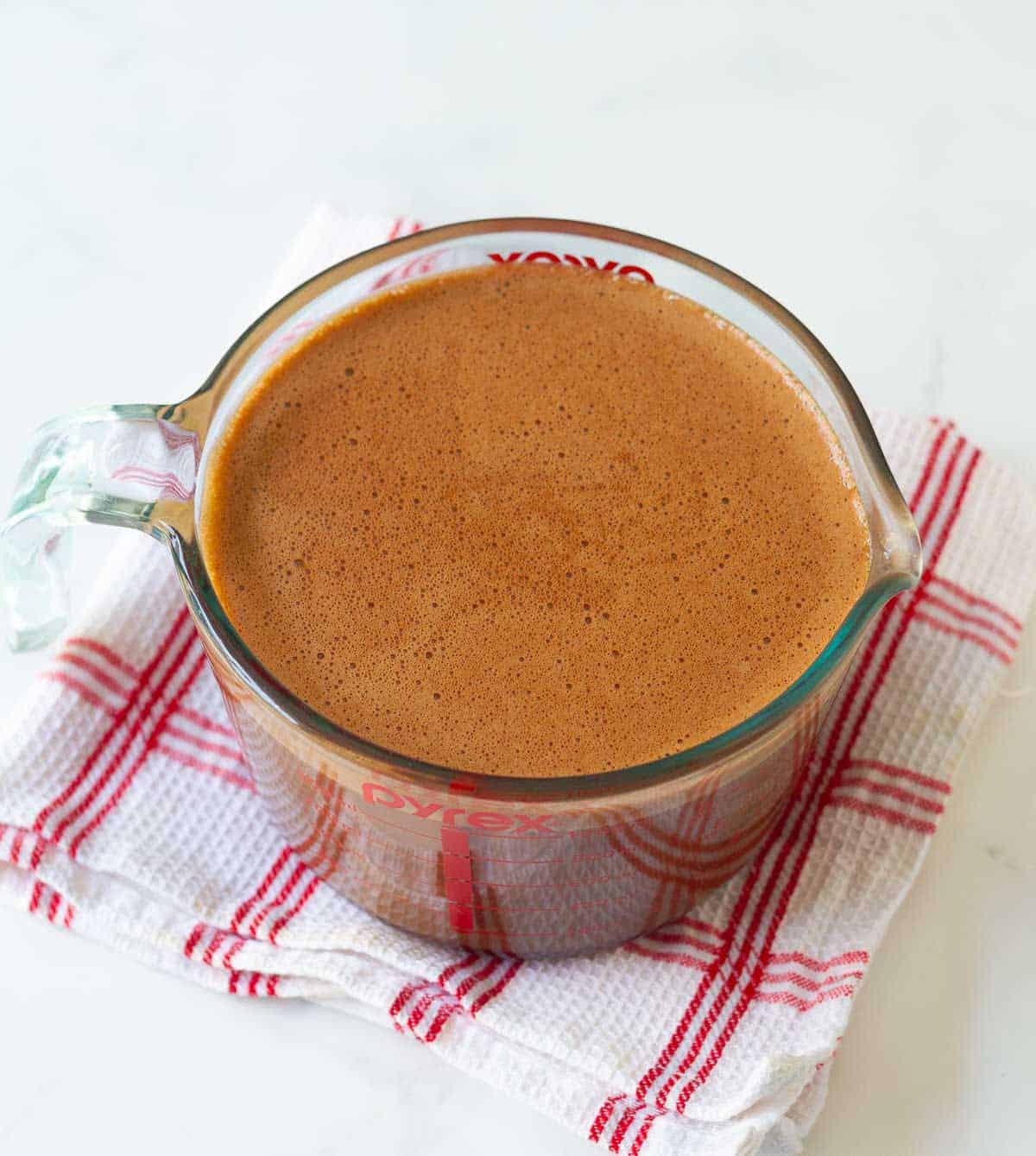 Chocolate cream mixture in a measuring cup.