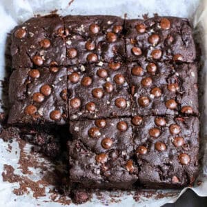 chocolate cherry cake cut into squares on parchment paper.