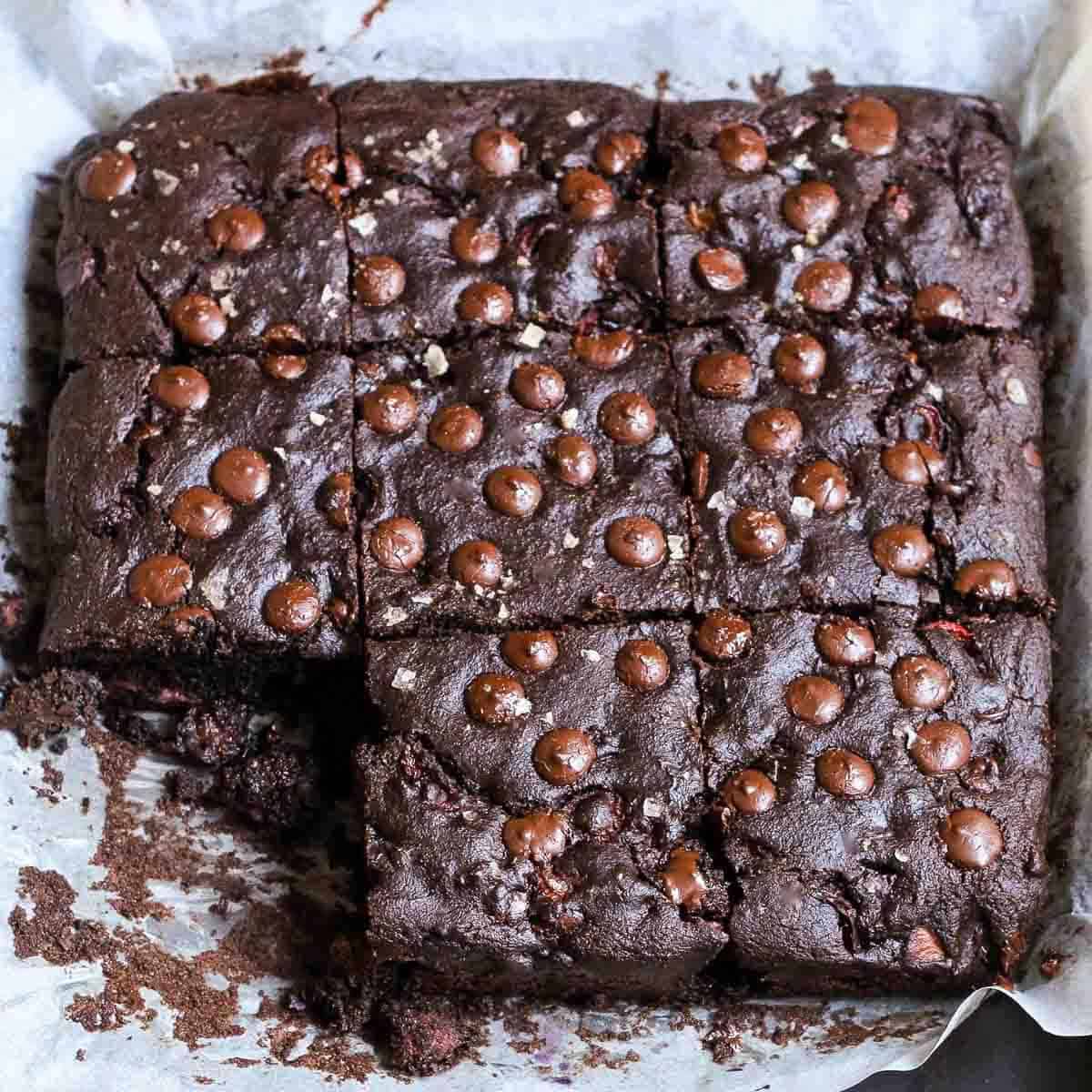 chocolate cherry cake cut into squares on parchment paper.