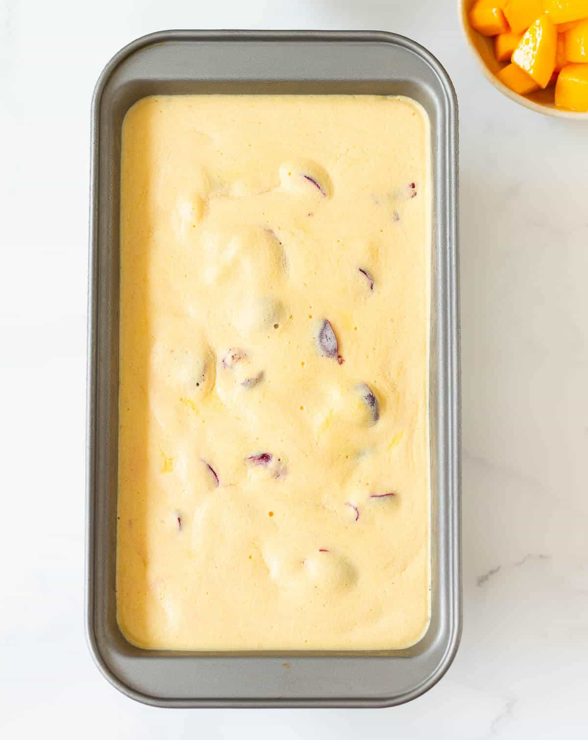 Mango frozen yogurt in a rectangular metal cake pan.