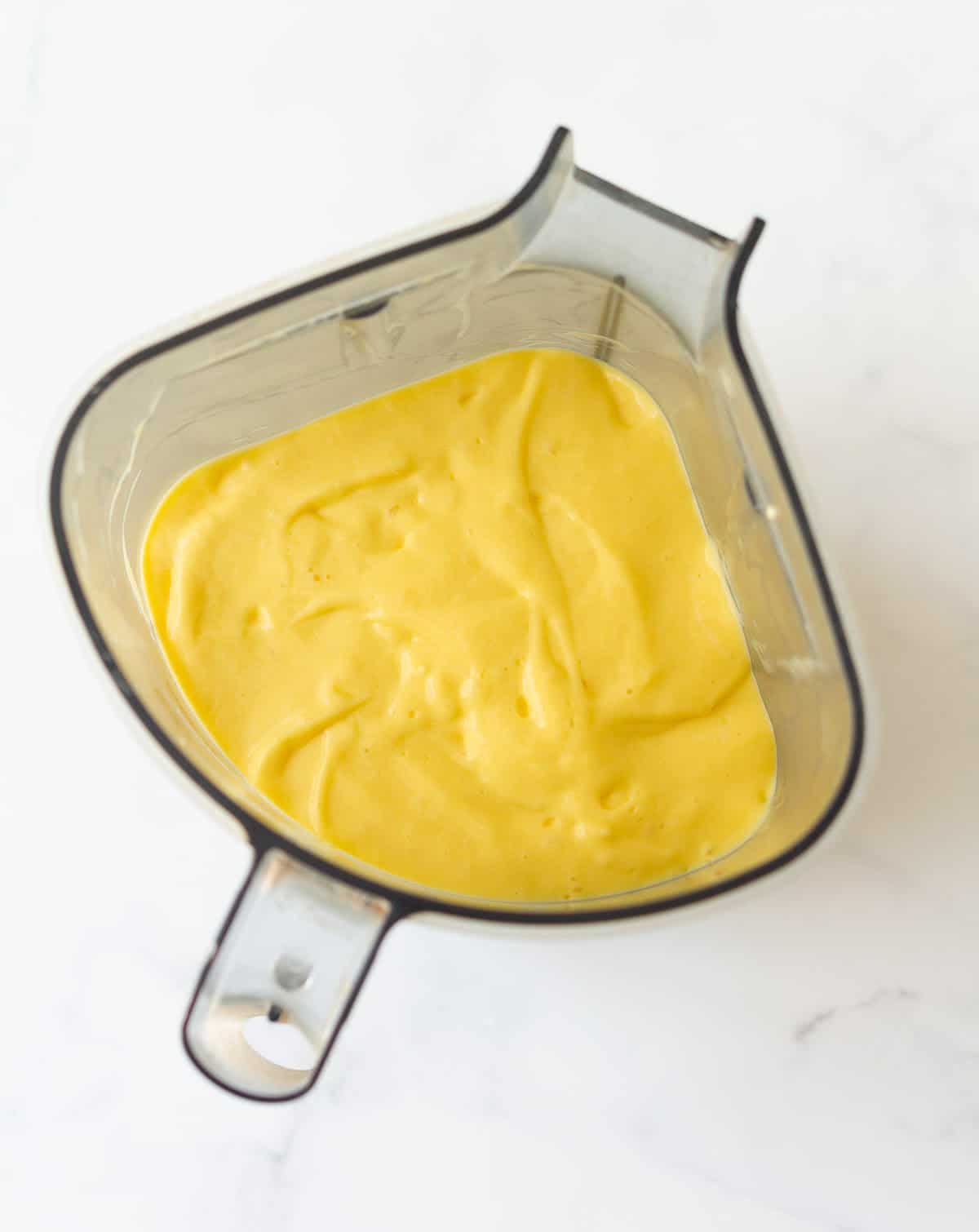 Blended mango yogurt mixture in a blender jar.