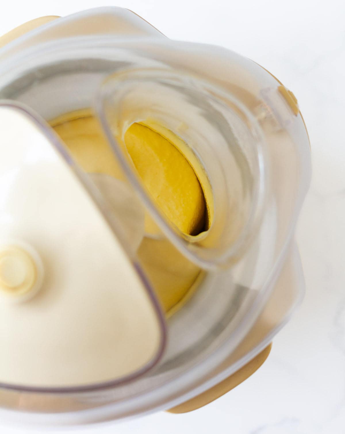 mango frozen yogurt getting churned in an ice cream maker.