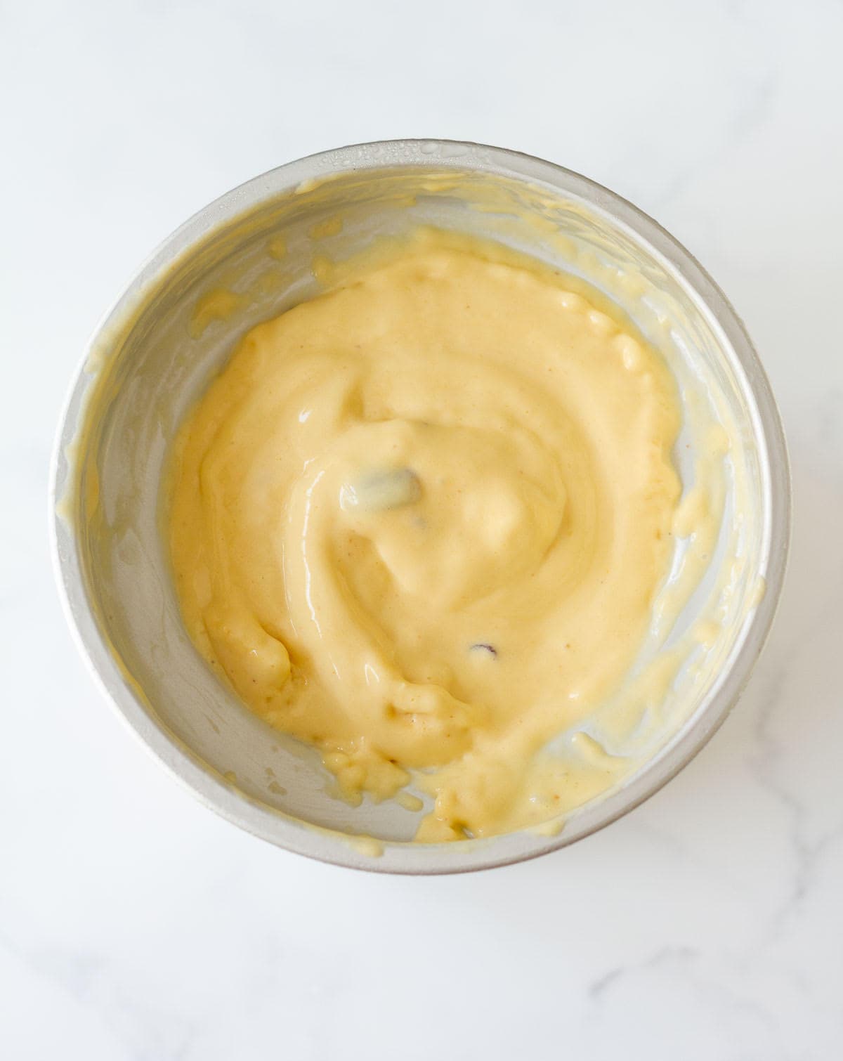 mango frozen yogurt in an ice cream maker canister.