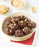 A plate of chocolate peanut butter no-bake cookies with ingredients around.