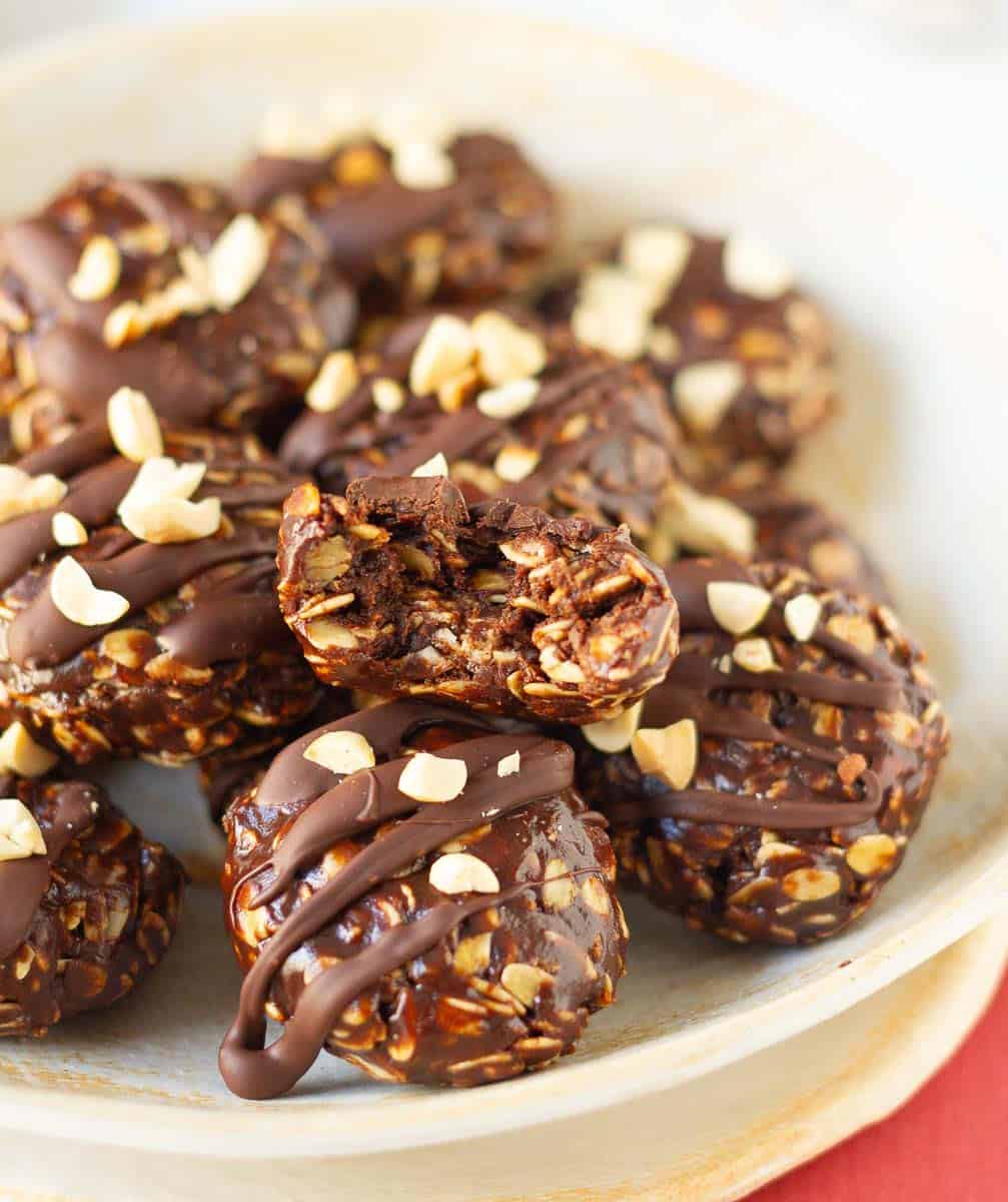 Chocolate No-Bake Cookies in a bowl with one cookie cut in half to show the texture.
