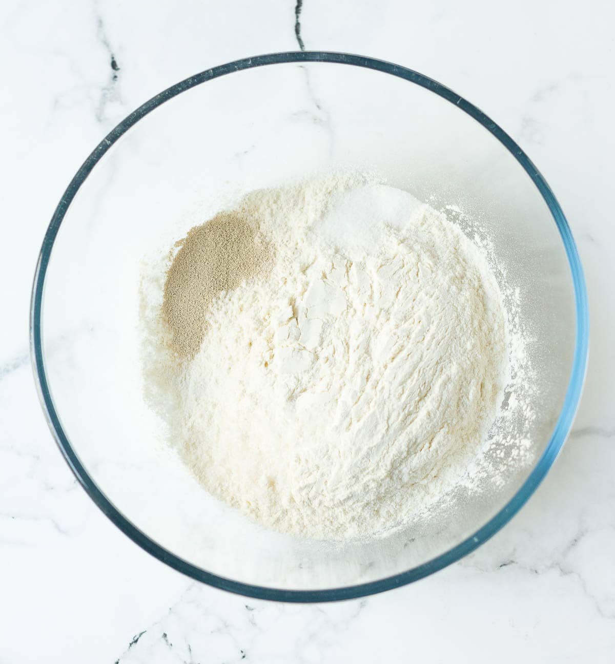 Flour, salt, sugar, and yeast in a mixing bowl.
