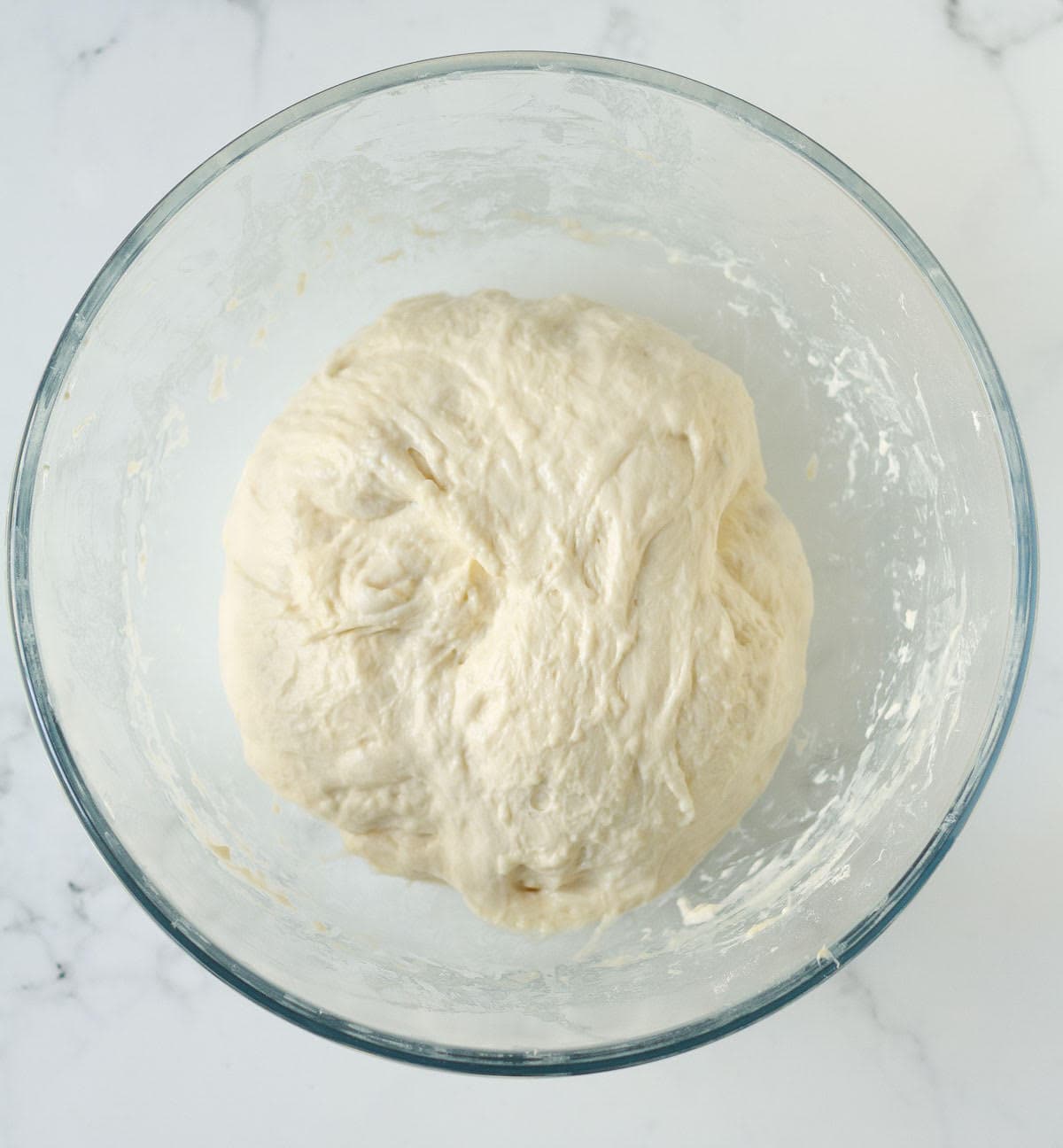 Dough in a glass bowl.