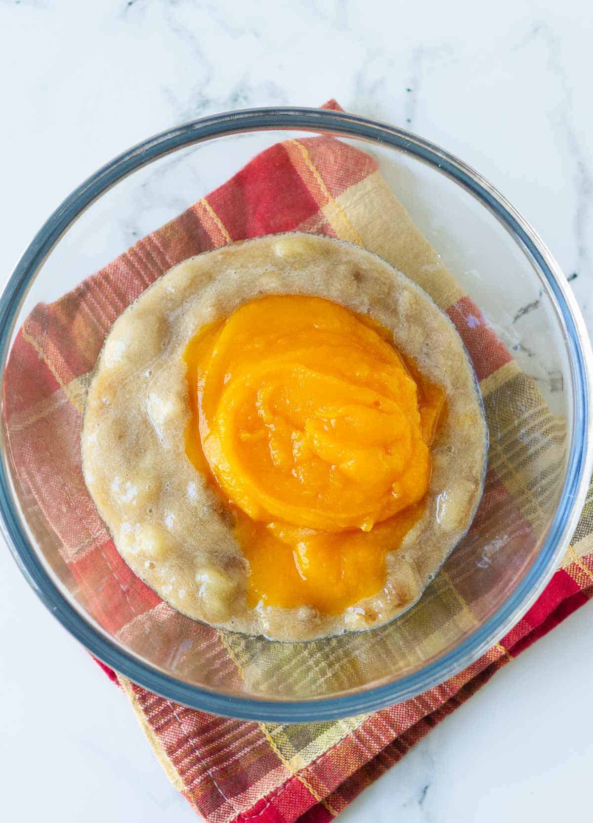 Mashed banana and pumpkin puree in a mixing bowl.