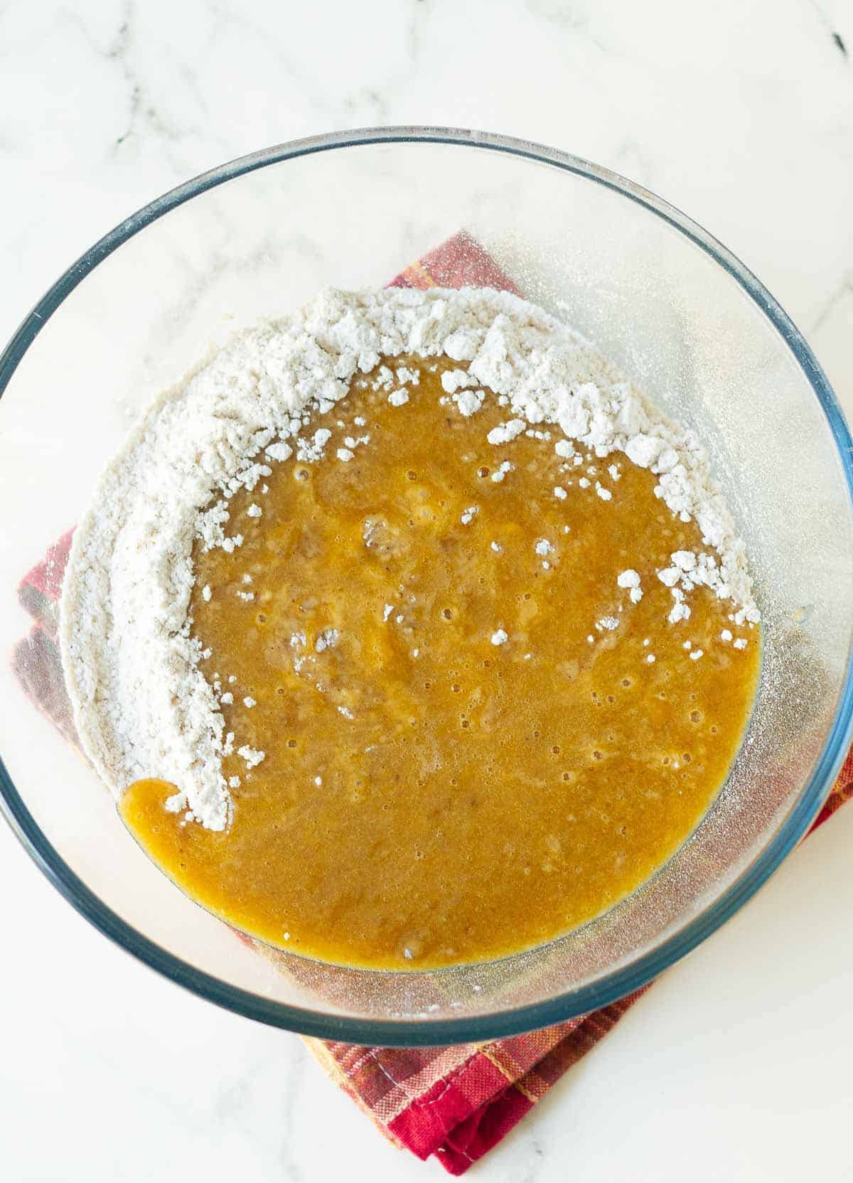 Dry and wet ingredients for making banana pumpkin bread in a bowl.