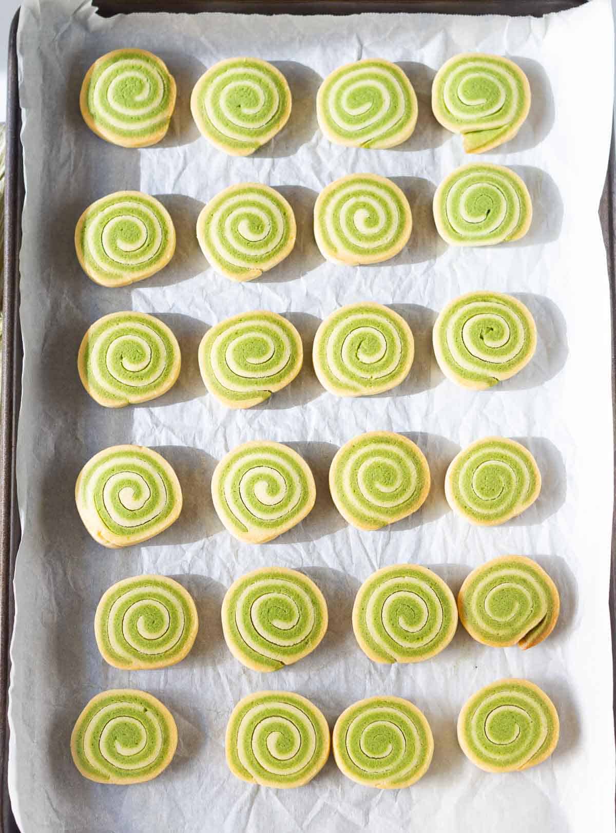 baked matcha cookies on parchment-lined baking tray.