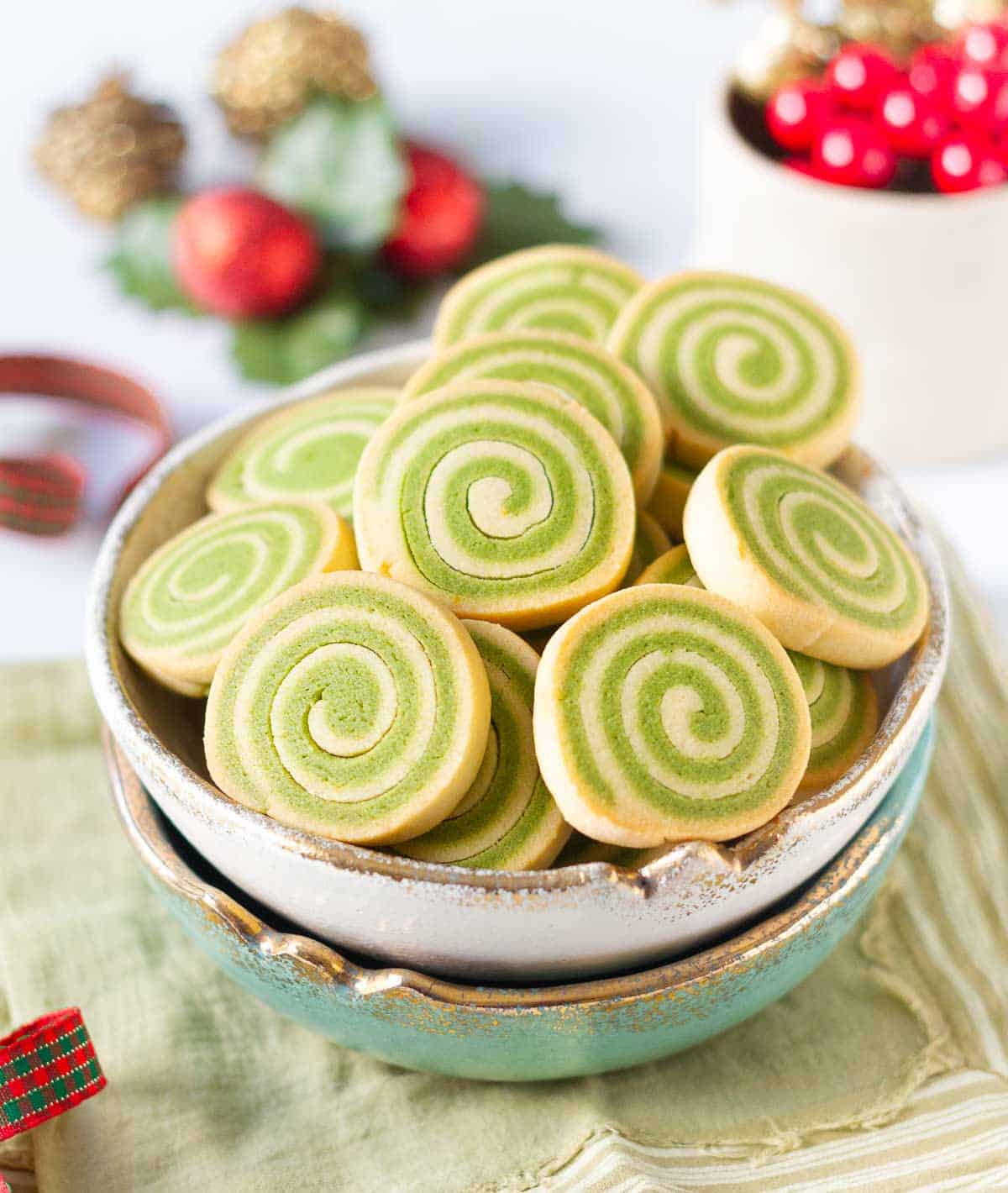 matcha pinwheel cookies in a serving bowl with festive decor in the background.