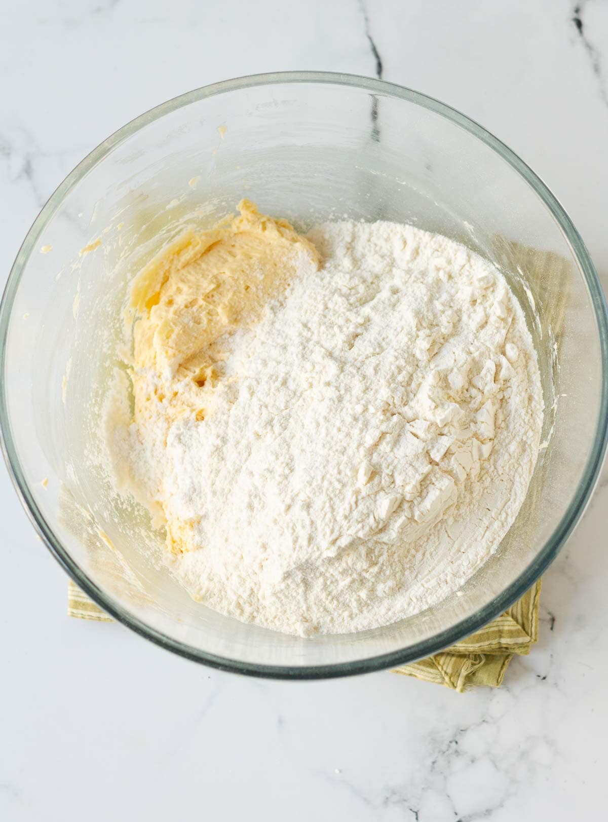 flour on top of the whipped butter, egg, and sugar mixture.
