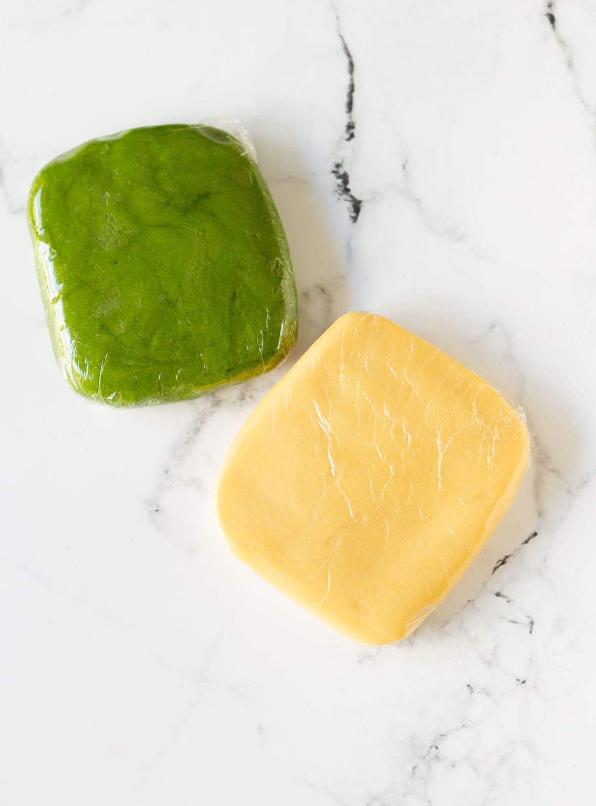 vanilla and matcha cookie dough wrapped in plastic wrap.