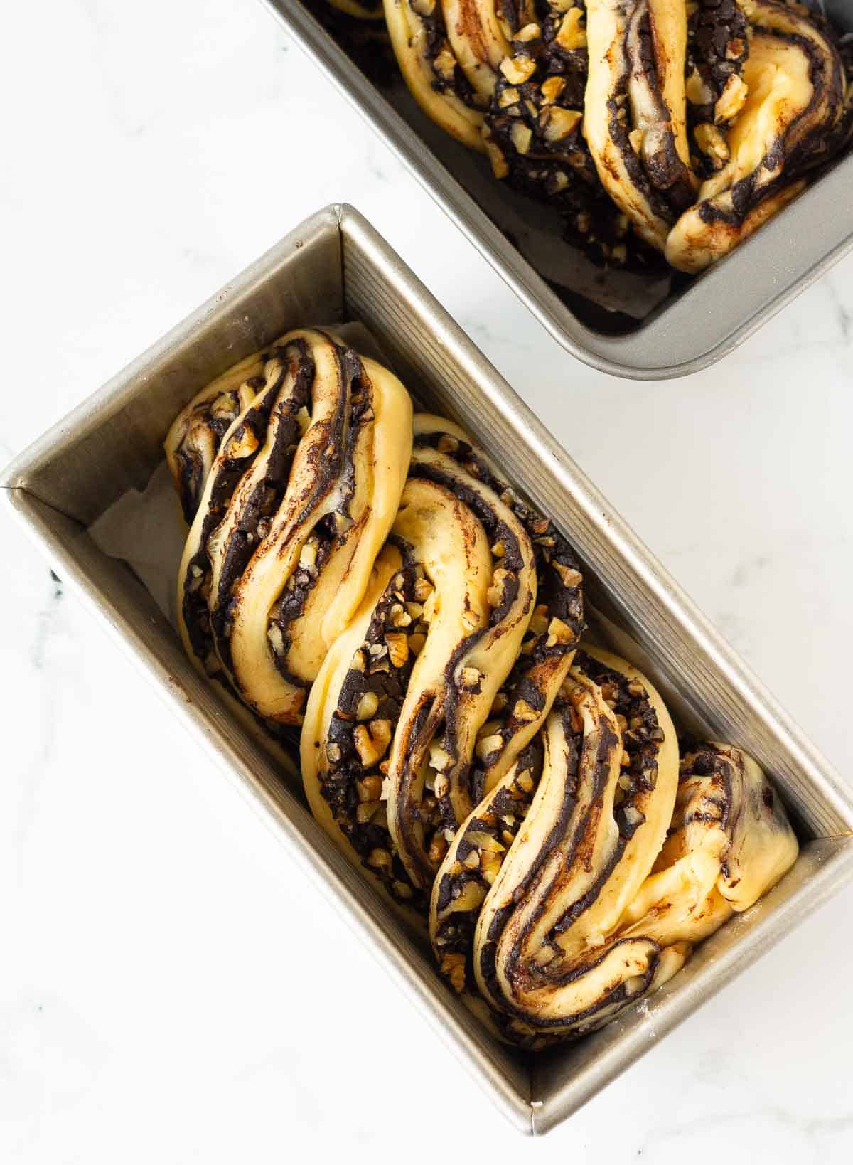 babka bread braids in 2 metal loaf pans.