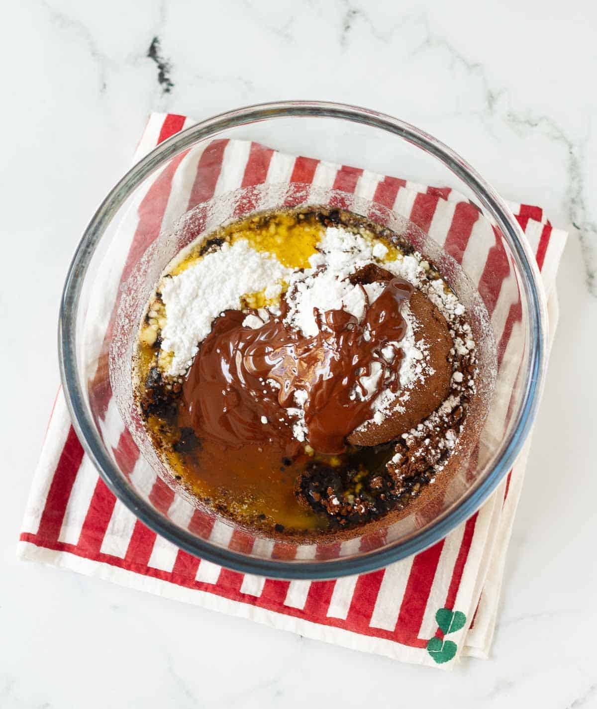 cocoa powder, melted chocolate, sugar, and melted butter in a small bowl.