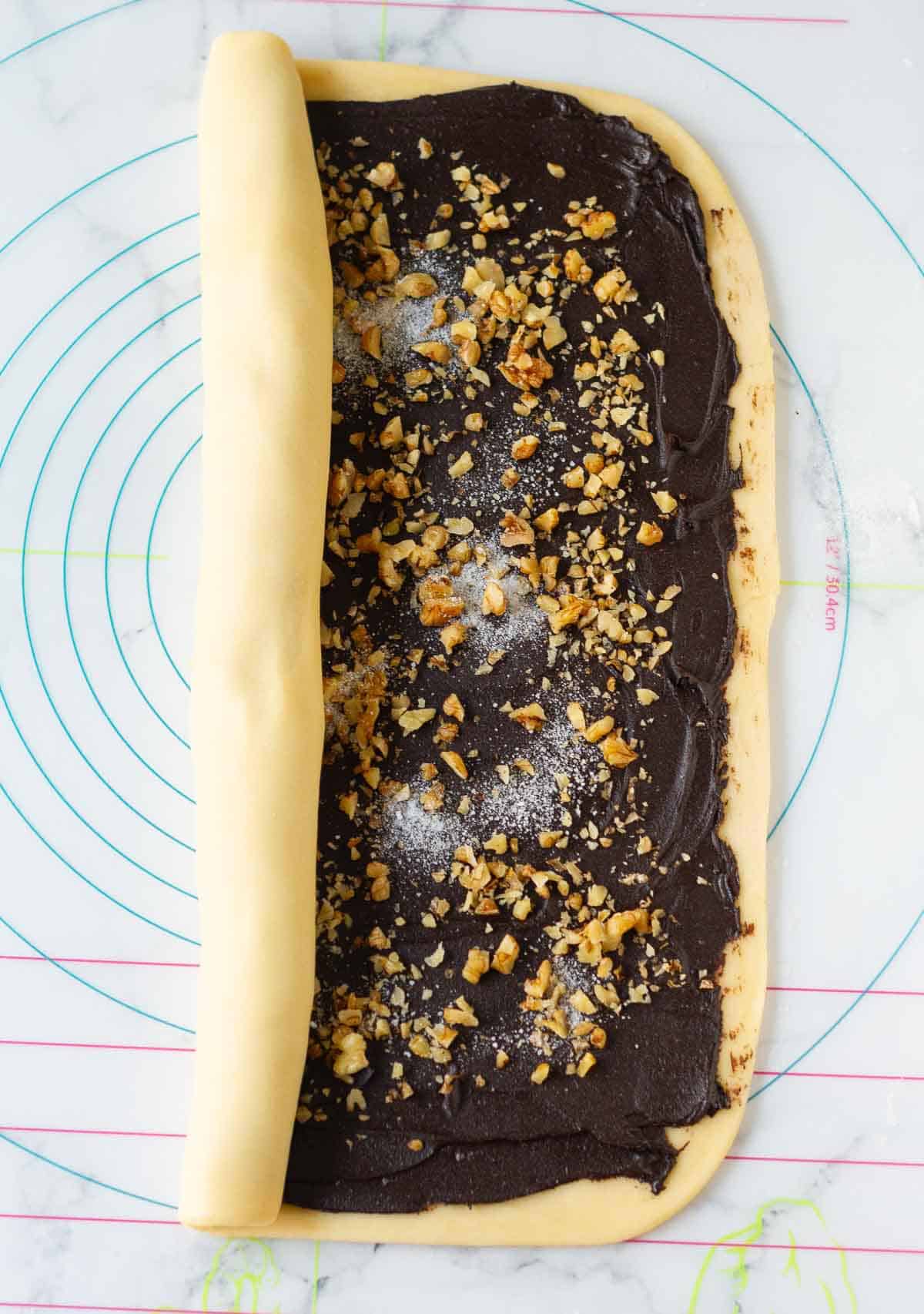 half rolled dough on a silicon mat.