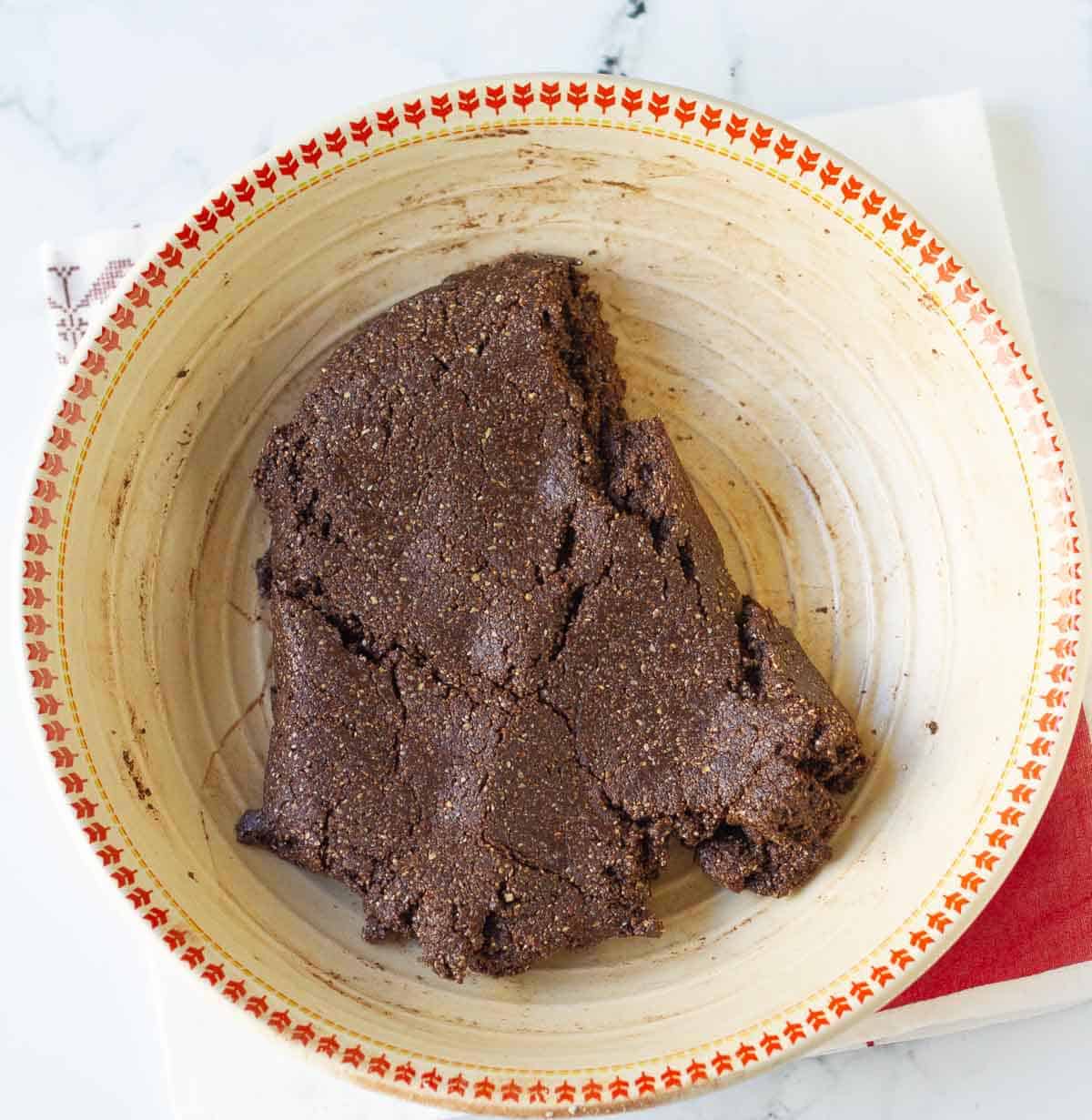 Dough for the chocolate tart crust in a bowl.