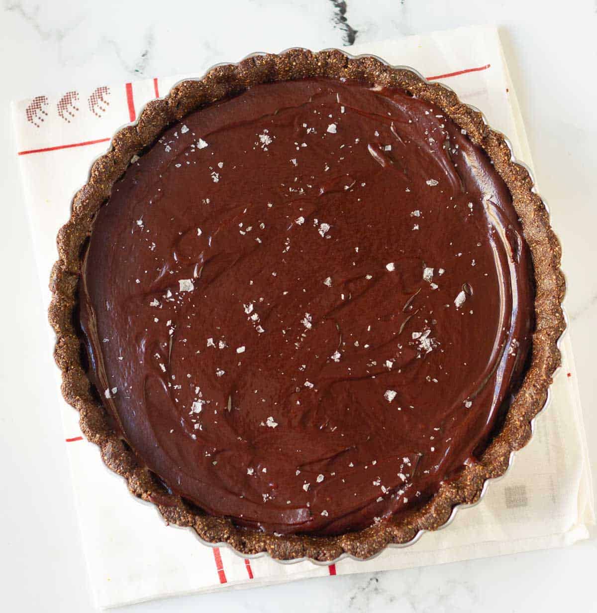 Chocolate ganache filling on the tart base topped with sea salt.