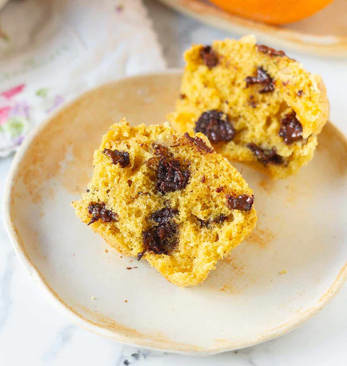 A muffin cut in half on a small plate.