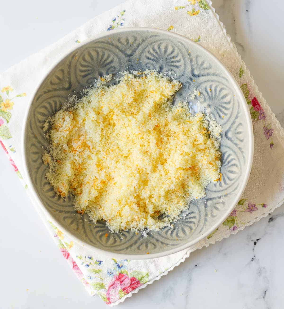 Mixture of orange zest and sugar in a bowl.
